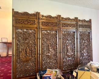 Chinese carved wood folding screen / room divider:  Tall carved hardwood folding screen (4+ panels) with pierced fretwork/lattice panels and carved relief medallions depicting Chinese immortals/sages, ornate scrolling floral crest.