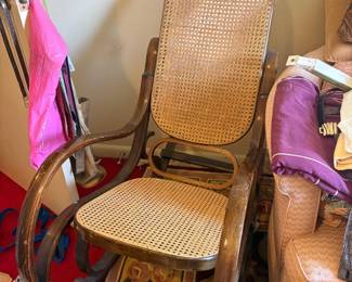 Bentwood cane rocking chair, Thonet-style: Vintage/mid-century bentwood rocking chair with woven cane seat and back panel, curved bentwood arms and frame, dark stained wood.