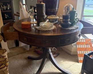 Regency-Style Leather-Top Drum Table:  Round drum-top occasional table with tooled leather top, banded drawers, tripod base with brass paw feet and casters. Underside label reads 'English Provincial Finish'