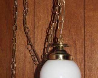 Vintage brass pendant light fixture with classic white globe shade