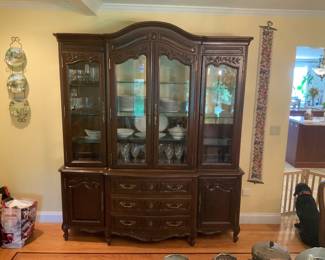 Ornately decorated china cabinet/display case w/ glass shelving. 87 1/4” H x 75” W x 17 1/2” D.