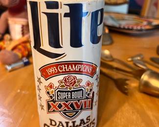 Vintage aluminum Miller Lite beer can commemorating the Dallas Cowboys as the 1993 Super Bowl XXVII champions. This white and blue collectible can is empty and has a pull-tab top. It is a piece of NFL memorabilia featuring the official Super Bowl XXVII logo and team name. The can has never been opened and feels about half full.