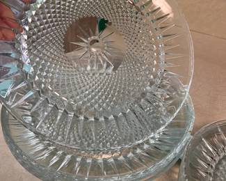 Elegant clear glass plates with a diamond-cut pattern and sunburst center. This set includes five (5) large 10" plates and seven (7) smaller 7.5" matching plates. The glass is thick with a textured underside and smooth top surface.
