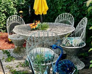 This mid-century modern Russell Woodard spun fiberglass dining set features a distinctive intricate weave design. The set includes a circular table and four matching chairs. 