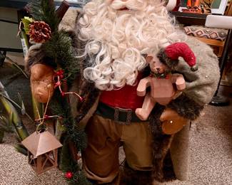 Woodland-style Santa Clause tabletop Christmas figurine with faux fur trim and a decorative pine branch holding a lantern.