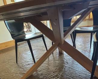Modern Round Oak Dining Table with XFrame Base and Black Molded Chairs third image