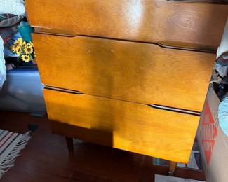 mid-century modern wooden tall chest of drawers featuring four stacked drawers with integrated sculpted lip pulls and tapered legs