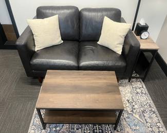 One of five matching modern leather loveseats; one of many matching modern industrial-style coffee tables.