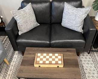 One of five matching modern leather loveseats; one of many matching modern industrial-style coffee tables.
