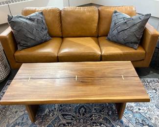 Modern leather sofa; World Market live edge rustic coffee table.