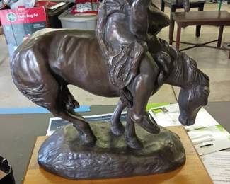 “The End of the Trail” by J. E. Fraser Decorative Sculpture  Large decorative reproduction of James Earle Fraser’s well-known The End of the Trail, depicting a weary Native American rider seated upon a bowed horse. Finished in a dark bronze tone and mounted on a wooden display base with an identifying brass-tone plaque.  This piece has significant damage and previous repairs to the horse’s rear legs, including visible white repair material, along with additional scratches, scuffs, finish wear, and other blemishes throughout. Material, maker, and age are unconfirmed. Sold as-is; please examine all photographs carefully for condition and repair details.