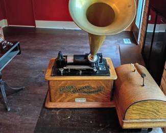 Antique Edison Standard Cylinder Phonograph with Horn and Cover  Antique Edison Standard hand-crank cylinder phonograph housed in an oak cabinet with a domed wooden carrying cover and original-style banner decal. The front plate reads: “Made for International Correspondence Schools, Scranton, Pa., by National Phonograph Co.” The mechanism is marked Thomas A. Edison and includes a removable brass-tone horn, winding crank, cylinder mandrel, reproducer assembly, carriage, and speed-control components.  The machine shows age-related wear, including scratches, scuffs, finish variation, oxidation, dust, and wear to the decals and metal components. Operating condition is unknown and the phonograph has not been tested. Completeness and originality of all components are not guaranteed, and no cylinder records are included unless otherwise stated. Sold as-is for collection, display, or restoration. Please review all photographs carefully.
