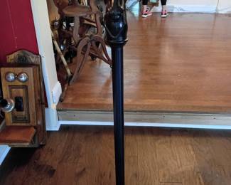 ast-Iron Horse-Head Hitching Post  Tall black metal hitching post featuring a detailed cast horse head with molded mane, upright ears, and a ring through the mouth for tying reins. Mounted to a rectangular wooden display base with a bolted metal plate. A striking equestrian accent suitable for a barn, stable, tack room, porch, garden, or Western-themed display.  Shows surface wear, scuffs, paint irregularities, and other blemishes consistent with age and outdoor-style use. The wooden base appears to be a later addition for freestanding display. Exact age and maker are unknown. Heavy item; buyer should bring appropriate help for removal. Please review all photographs carefully for condition.