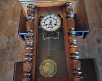 Antique Ornate Wooden Wall Clock – Restoration Project  Antique weightless pendulum wall clock housed in an ornate wooden case with turned columns, carved accents, decorative finials, glass panels, Roman-numeral dial, two winding holes, pendulum, and visible mechanical movement. The exact maker, age, and country of origin are unknown.  This clock is in poor, partially disassembled condition with loose and separated case sections, missing or damaged trim, scratches, finish wear, dust, and other age-related damage. Some pieces may be missing, and the mechanical condition is unknown. Not tested and not guaranteed to operate. Best suited for restoration, repair, display, or parts. Sold as-is with only the components shown; please examine all photographs carefully.