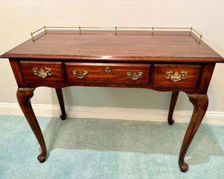 Henkel Harris Queen Anne-style cherry vanity or writing desk featuring a decorative brass gallery rail and graceful cabriole legs.$900