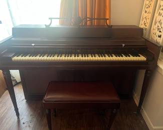 Vintage Wurlitzer Spinet Piano with Bench  Description: Classic dark wood Wurlitzer spinet piano featuring tapered legs and a matching storage bench with a faux-leather cushioned top.  Condition: Good vintage condition with standard cosmetic wear; keys and bench are intact.