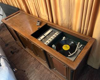 Magnavox Astro-Sonic Stereo Console. Vintage wooden console cabinet featuring a built-in Magnavox Micromatic record player and AM/FM radio receiver.  Condition: Working condition includes original instruction envelope.