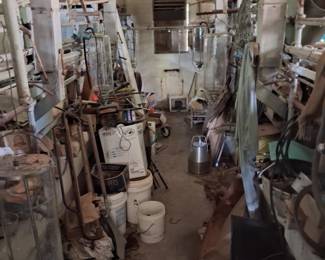 Old milking stalls full of milking equipment and large glass jugs
