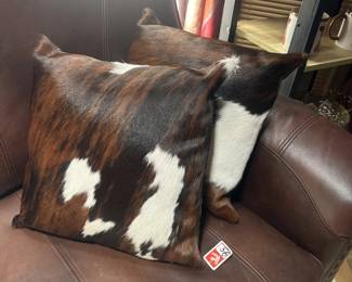leather loveseat and cowhide pillows
