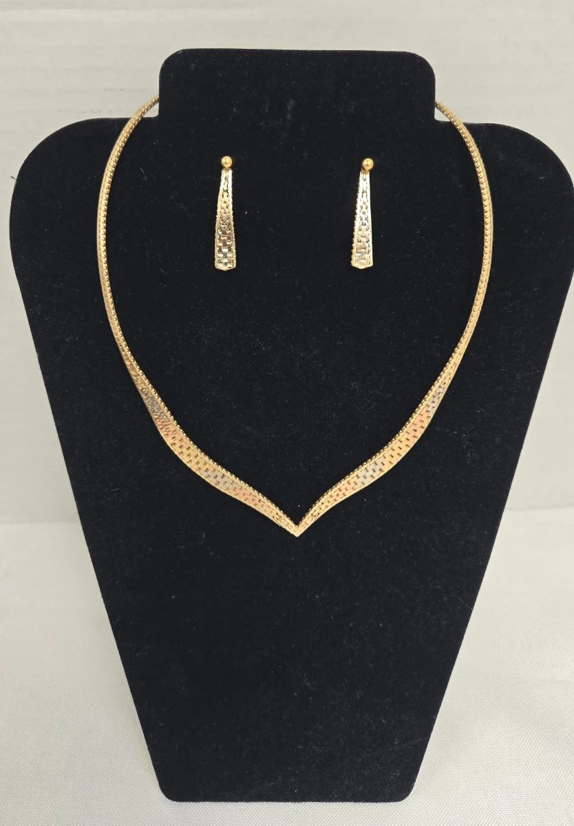 This vintage gold tone jewelry set pairs a coordinating necklace and earrings in a classic mid-century style that holds up beautifully today. Estate jewelry sets like this are a favorite among costume jewelry collectors for their coordinated look and retro elegance. A lovely addition to any vintage jewelry collection or a thoughtful gift for a jewelry enthusiast.