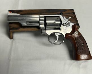 This Smith & Wesson stainless steel revolver features a 4-inch barrel, checkered wood grips, and a clean stainless finish. Smith & Wesson stainless revolvers in this configuration are perennial favorites among collectors and defensive shooters alike for their balance of durability and classic aesthetics. A well-preserved example from an estate with strong collector and shooter appeal.