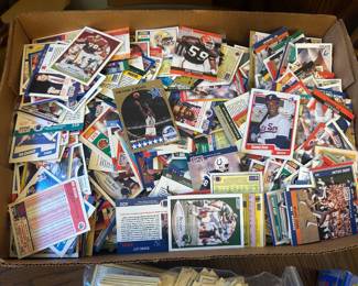 This box lot of vintage sports cards spans early 1990s football, baseball, and basketball and includes brands like Fleer, Score, Pro Set, and NBA Hoops. A Michael Jordan NBA Hoops card and a Sammy Sosa Fleer card are visible among hundreds of cards — making this a solid junk wax era sports card lot worth digging through. Perfect for collectors hunting key cards from the early 1990s trading card boom.