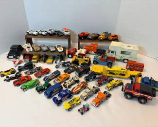 This lot holds fifty-plus die-cast and pressed-steel vehicles including semi tractors, police cruisers, hot rods, dune buggies, sports cars, a double-decker bus, a fire truck, a motorcycle, a jet, a camper truck, and a 4x4 pickup. Recognizable markings visible in the photo include Tonka, Mazda RX-7, Exxon, and Cobra. Condition varies across the group from bright paint to well-played-with — a big-volume lot for collectors, resellers, or a kid's toy box.