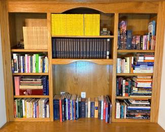 This bookcase lot includes a bound Animal Kingdom encyclopedia set, a full World Book Encyclopedia set with yearbook, and a long run of yellow-spine National Geographic magazines. The remaining shelves hold fiction and reference titles including Robert Jordan's Wheel of Time volumes, Isaac Asimov paperbacks, an unabridged Webster's dictionary, Roget's Thesaurus, and a wide mix of art, nature, and general-interest hardcovers. A great bulk book lot for readers, resellers, or anyone filling shelves.