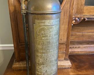 This antique brass fire extinguisher is a 2½-gallon hand-operated pump type, bearing the "Guardene" trade name with a beautifully patinated embossed label. Vintage fire extinguishers like this are highly sought as industrial antiques and steampunk décor, and this one displays the original brass finish and intact nozzle assembly. A standout piece for collectors of antique firefighting equipment or early 20th century Americana.