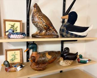 This lot brings together a group of decorative duck decoys in painted wood, ceramic, and fabric, along with a large painted game bird figure and a duck-form lidded dish. Two small framed duck prints in wood frames round out the grouping. A cohesive collection for anyone decorating a lodge, cabin, den, or hunting-themed room with waterfowl décor.