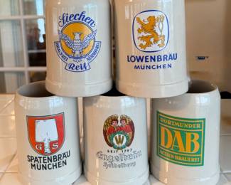 This lot of five stoneware beer steins carries brewery graphics including Löwenbräu München, Spatenbräu München, Dortmunder DAB Actien Brauerei, and a Heidelberg tavern design, plus one additional brewery-marked stein. All are the straight-sided .5L style with molded handles and colorful transfer decoration. A ready-made collection for a bar, game room, or German beer memorabilia collector.
