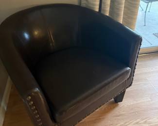 Brown faux-leather barrel chair with nailhead trim