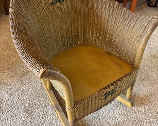 Antique child's barrel-back wicker rocking chair, a classic piece of children's furniture dating to the early 20th century (circa 1910–1930)