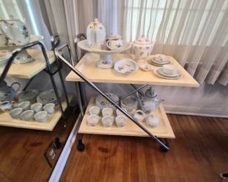 mid-century modern folding serving cart features a chrome tubular frame and cream laminate trays in casters 