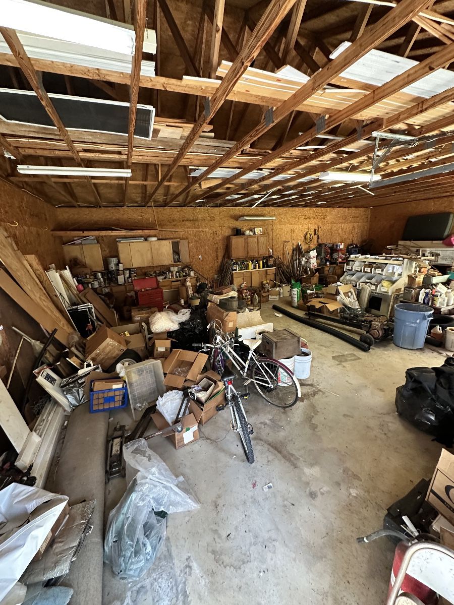 Packed workshop and garage with tools, bicycles, hardware, storage, and shop equipment.