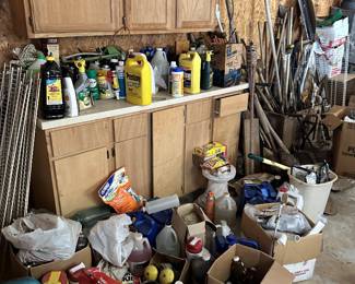 Workshop storage cabinet with paints, oils, sprays, and hardware.