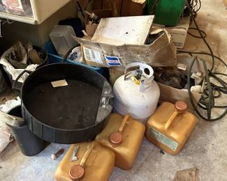 Propane cylinder, fuel containers, large metal pan, and shop supplies.