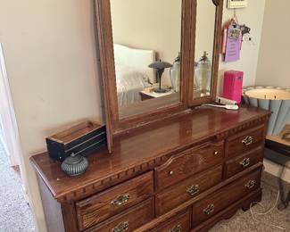 Wooden dresser with mirror and drawers.