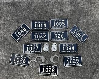 Guantanamo Bay metal license plates with Navy Police badges, handcuffs, and related military collectibles.