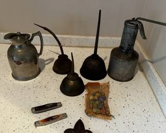 Vintage metal oilers, pocket knives, small tools, and decorative metal collectibles.