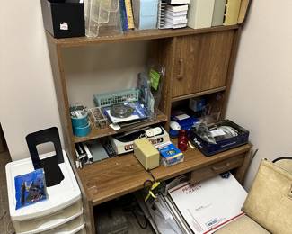 Office bookcase, desk electronics, calculators, and supplies.