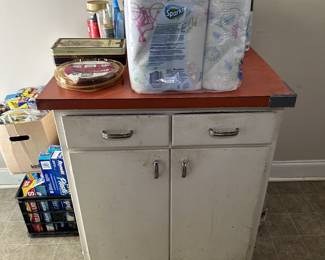 Metal utility cabinet with drawers and bottled water.