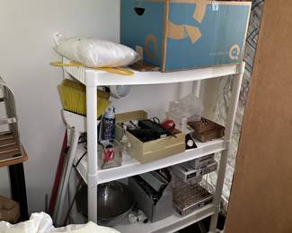 Utility shelf with small appliances, kitchenware, and household goods.