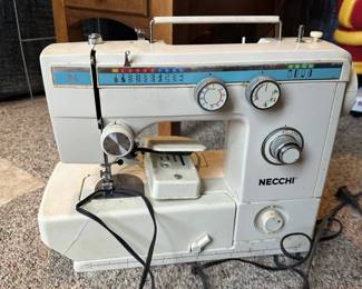 Vintage Necchi sewing machine with cabinet and accessories.