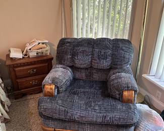 Upholstered recliner and wooden nightstand.