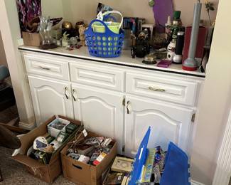 Cabinet with bottles, figurines, and collectibles.