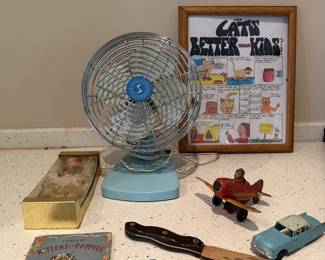 Vintage electric fan, framed cat art, toys, and collectibles.