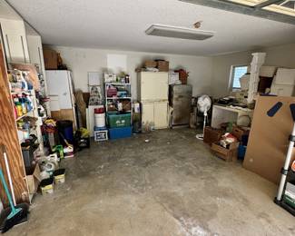 Garage storage room with shelving, appliances, and boxes.