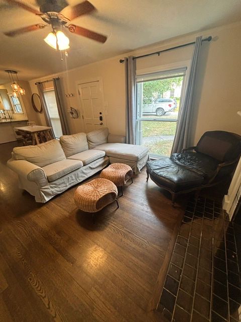 Slipcovered sofa, wicker ottomans, Two black leather French Provincial-style Bergère chairs with matching ottoman