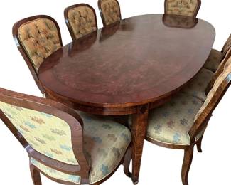 Switzer Oval Burled Poplar Dining Table with Cherry and Ebony Insets and Solid Brass Feet - seats 12 and includes two 20" extensions and custom table pads. 12 Rhulmann Side Dining Chairs in Olivewood Veneer with Tufted Backs